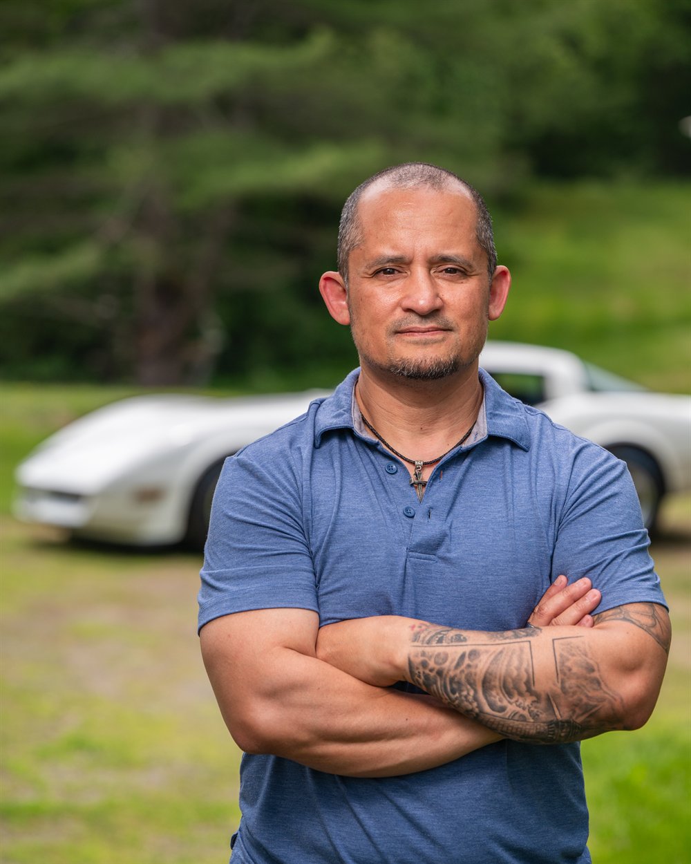 Ken Allen standing with his classic Corvette